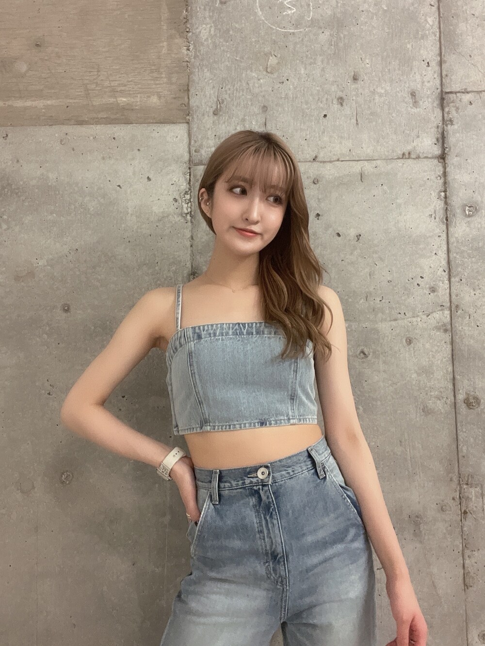 ブルー系のデニムパンツ、ホワイト系のパンプス、ブルー系のキャミソールを着用したレディースの夏コーディネートの3枚目の写真