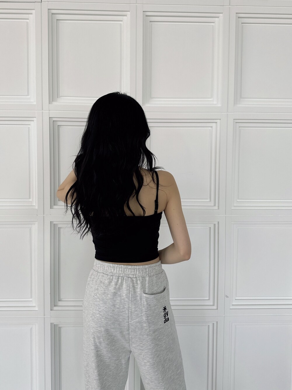 ブラック系のキャミソール、グレー系のスウェットパンツ、ブラック系のスニーカーを着用したレディースの夏コーディネートの2枚目の写真