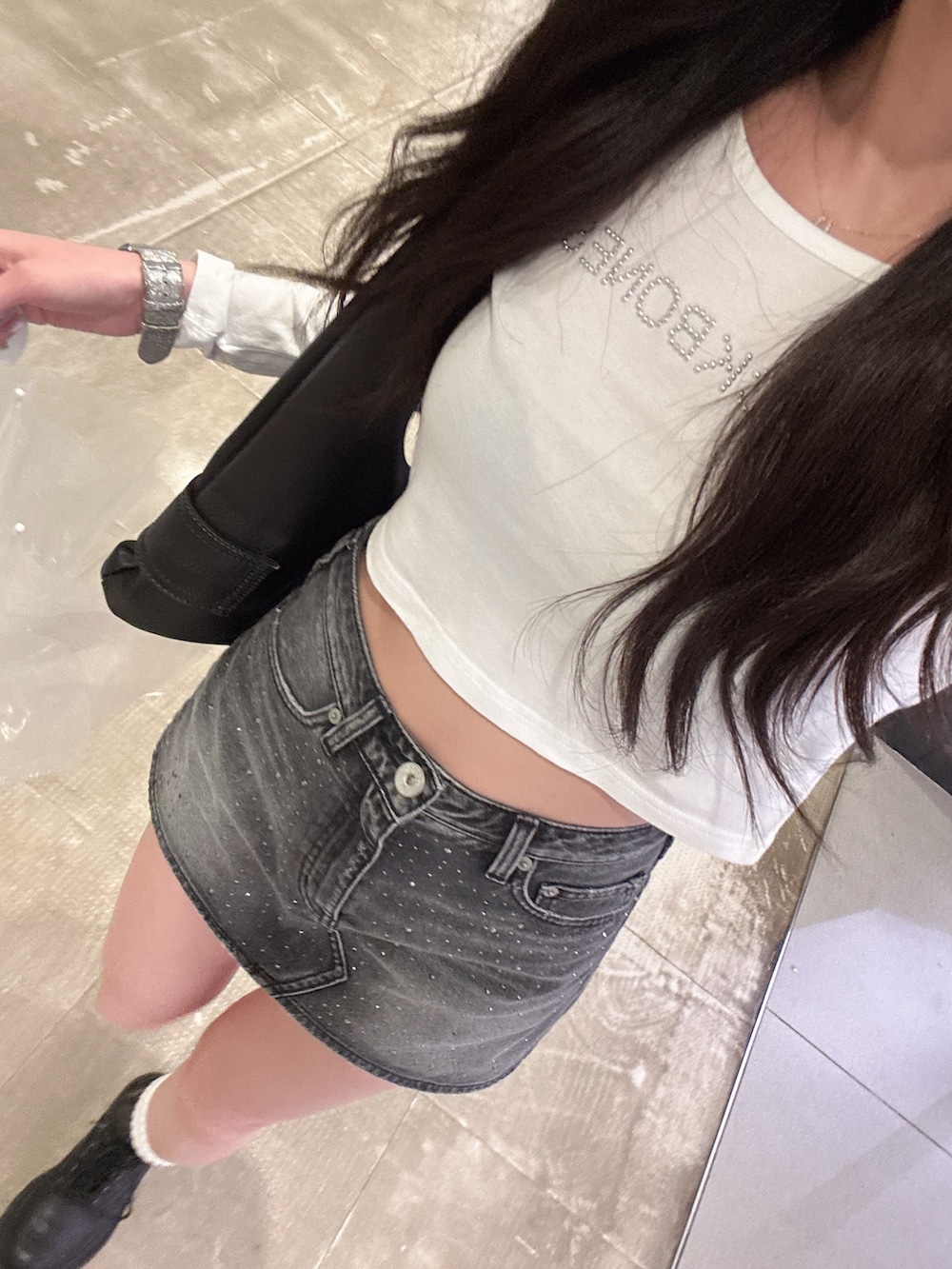 ホワイト系のTシャツ/カットソー、ブラック系のデニムスカートを着用したレディースの春コーディネートの2枚目の写真