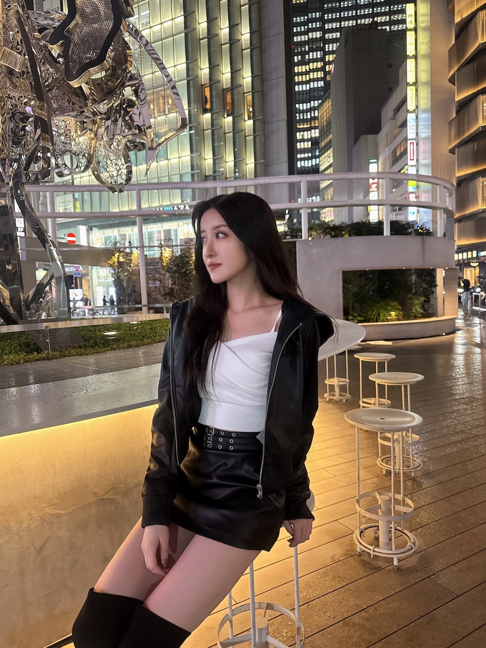 ブラック系のスカート、ブラック系のブルゾン、ホワイト系のTシャツ/カットソーを着用したレディースの春コーディネートの2枚目の写真