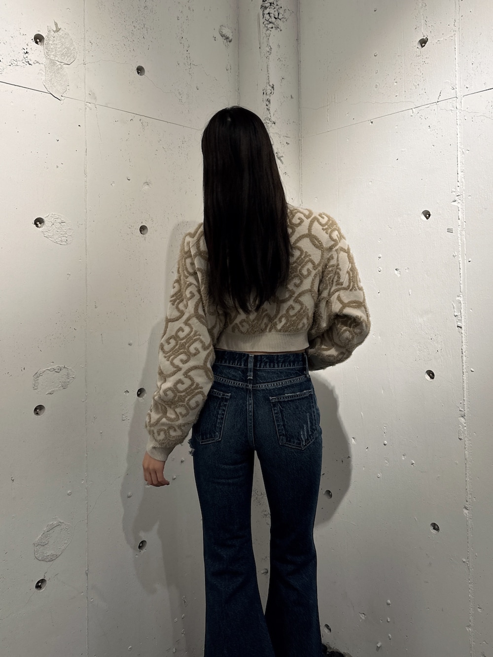 ホワイト系のニット/セーター、ブルー系のデニムパンツ、ブラック系のパンプスを着用したレディースの秋コーディネートの4枚目の写真