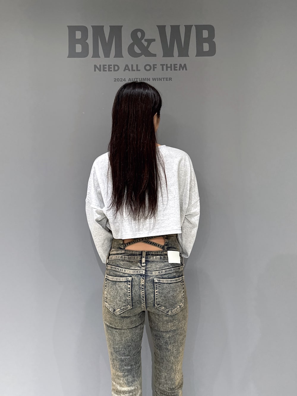 グレー系のTシャツ/カットソー、ブルー系のデニムパンツ、ブラック系のブーツを着用したレディースの秋コーディネートの5枚目の写真