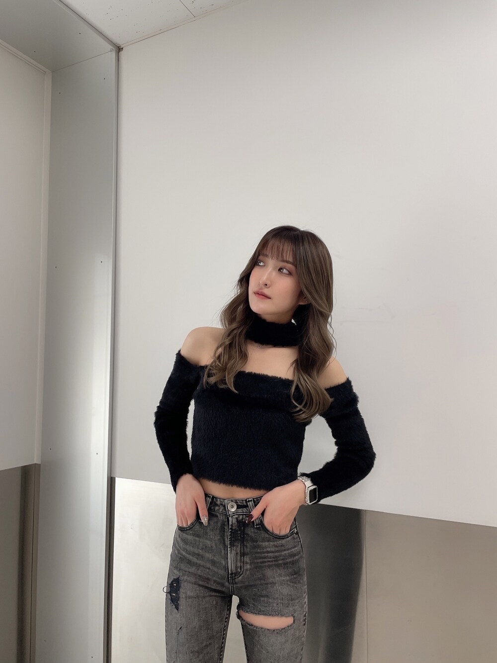 ブラック系のデニムパンツ、ブラック系のニット/セーター、ブラック系のパンプスを着用したレディースの秋コーディネートの5枚目の写真