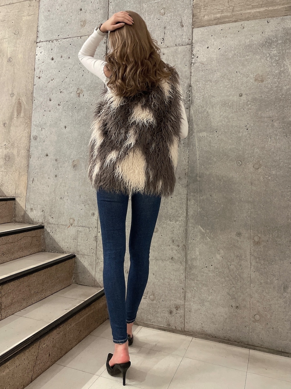 ホワイト系のTシャツ/カットソー、その他のベスト、ブルー系のデニムパンツを着用したレディースの秋コーディネートの2枚目の写真