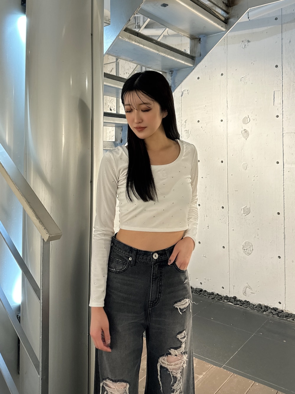 ホワイト系のTシャツ/カットソー、ブラック系のデニムパンツ、ホワイト系のパンプスを着用したレディースの秋コーディネートの3枚目の写真