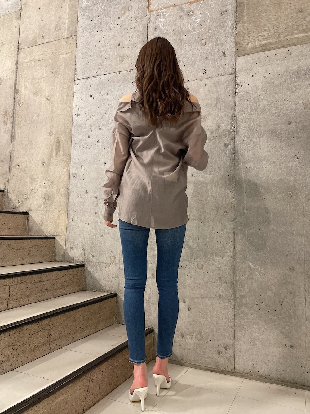 ベージュ系のシャツ/ブラウス、ブルー系のデニムパンツ、ホワイト系のパンプスを着用したレディースの春コーディネートの2枚目の写真