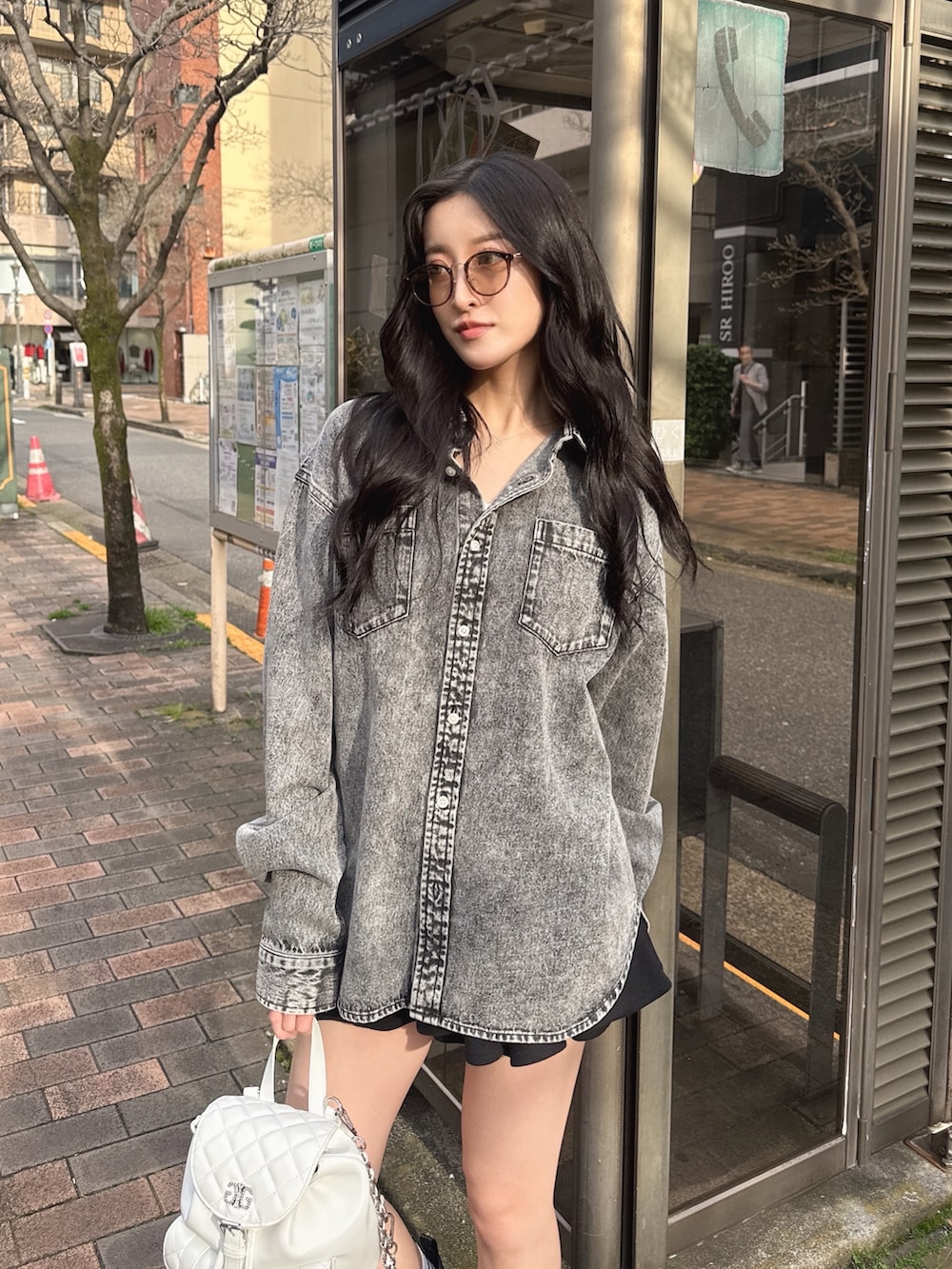 ブラック系のシャツ/ブラウス、ブラック系のスカート、ホワイト系のバックパック/リュックを着用したレディースの春コーディネートの2枚目の写真