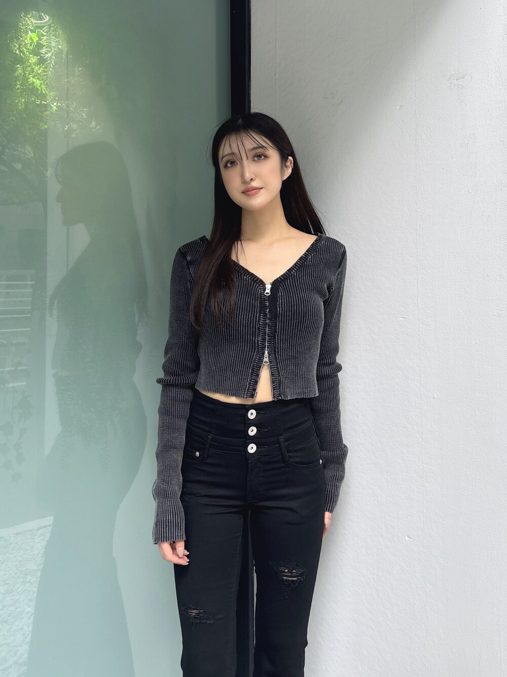 ブラック系のニット/セーター、ブラック系のデニムパンツ、ブラック系のブーツを着用したレディースの秋コーディネートの3枚目の写真