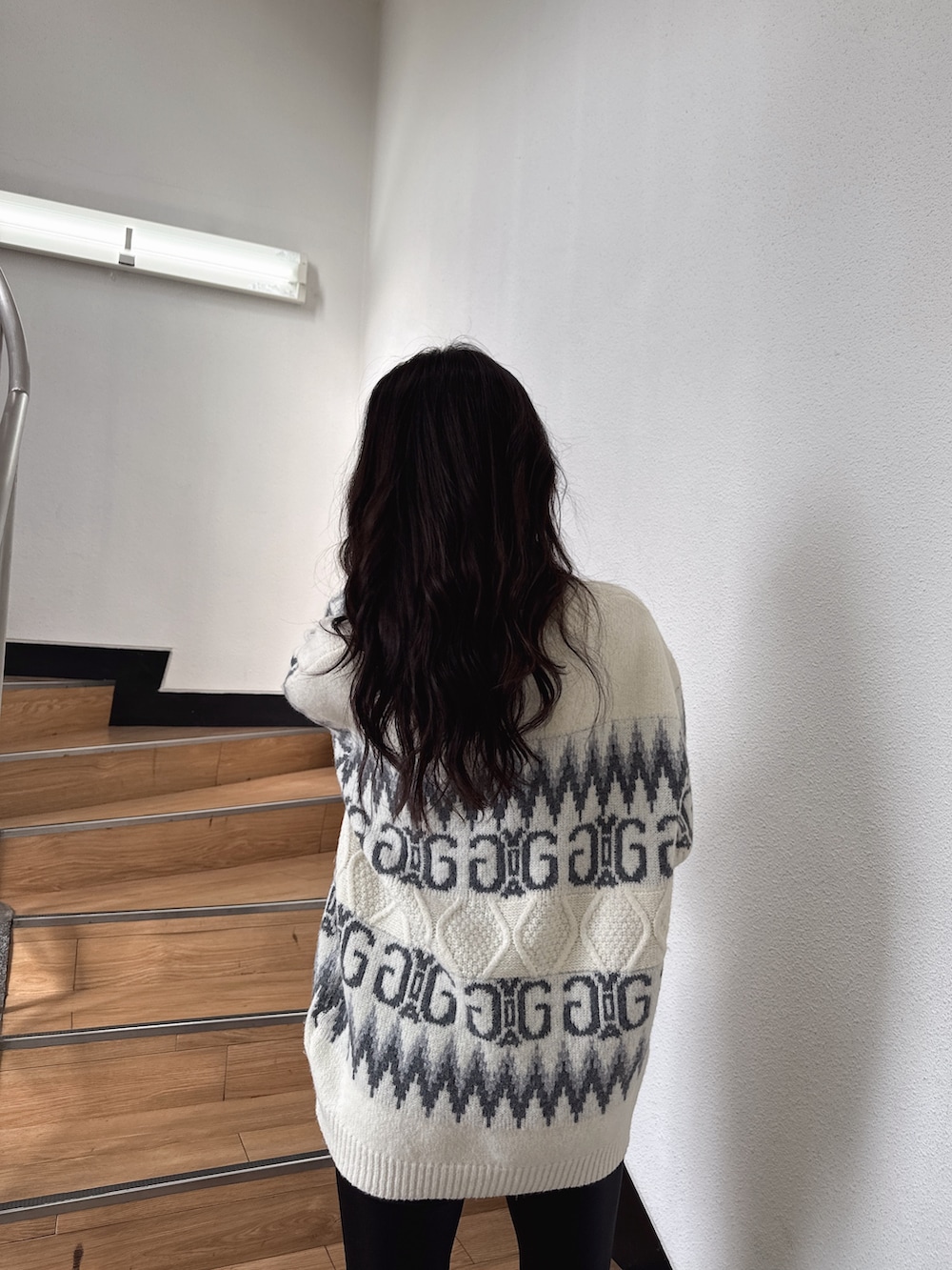 ホワイト系のニット/セーター、ブラック系のその他パンツ、ブラック系のパンプスを着用したレディースの冬コーディネートの4枚目の写真