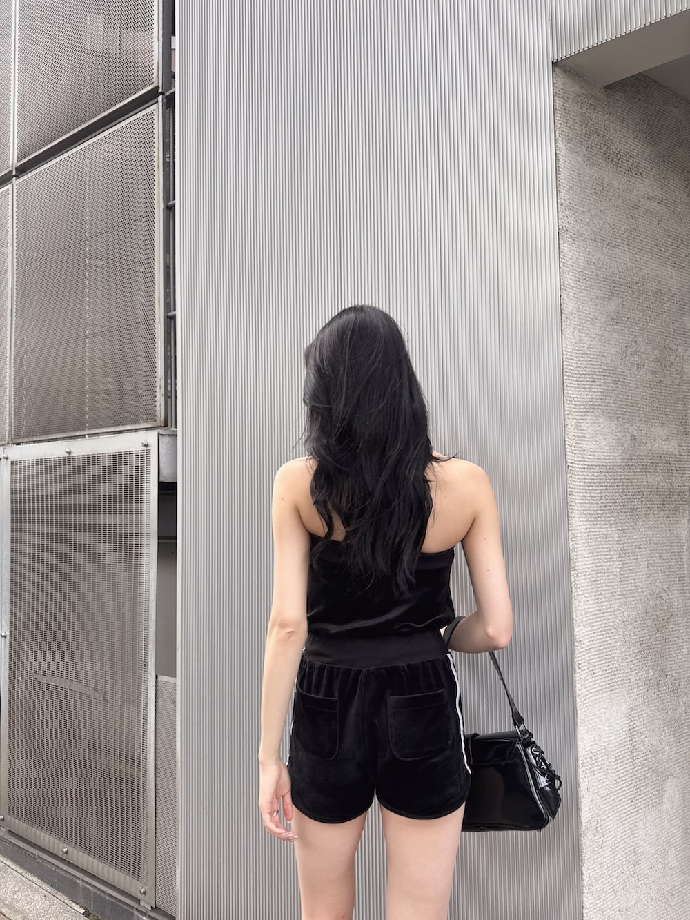 ブラック系のワンピース、ブラック系のハンドバッグ、ブラック系のサンダルを着用したレディースの夏コーディネートの4枚目の写真