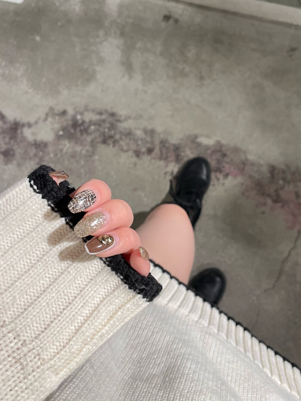 ホワイト系のニット/セーター、ブラック系のスカート、ブラック系のブーツを着用したレディースの冬コーディネートの6枚目の写真