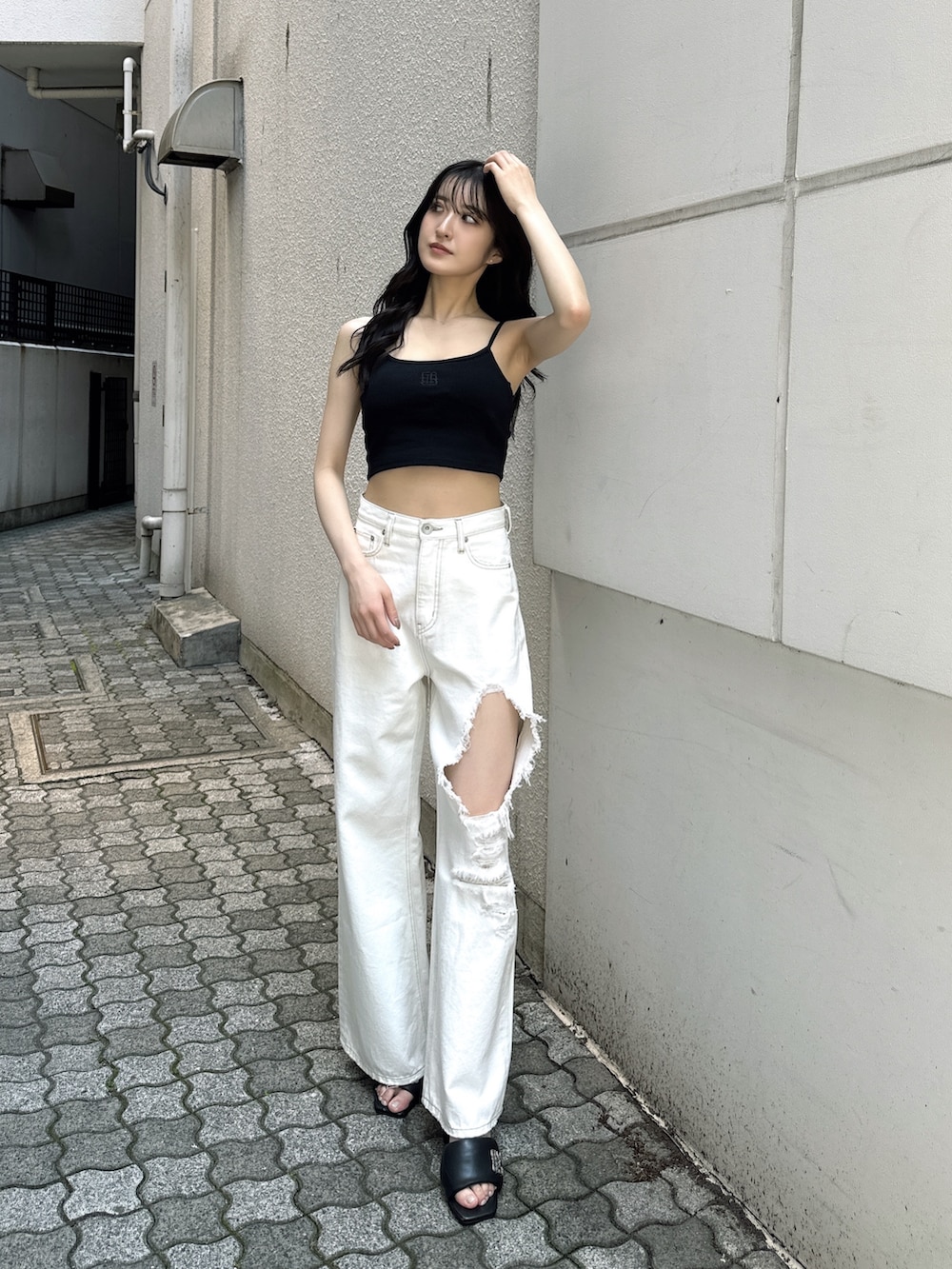 ホワイト系のデニムパンツ、ブラック系のキャミソール、ブラック系のサンダルを着用したレディースの夏コーディネートの3枚目の写真