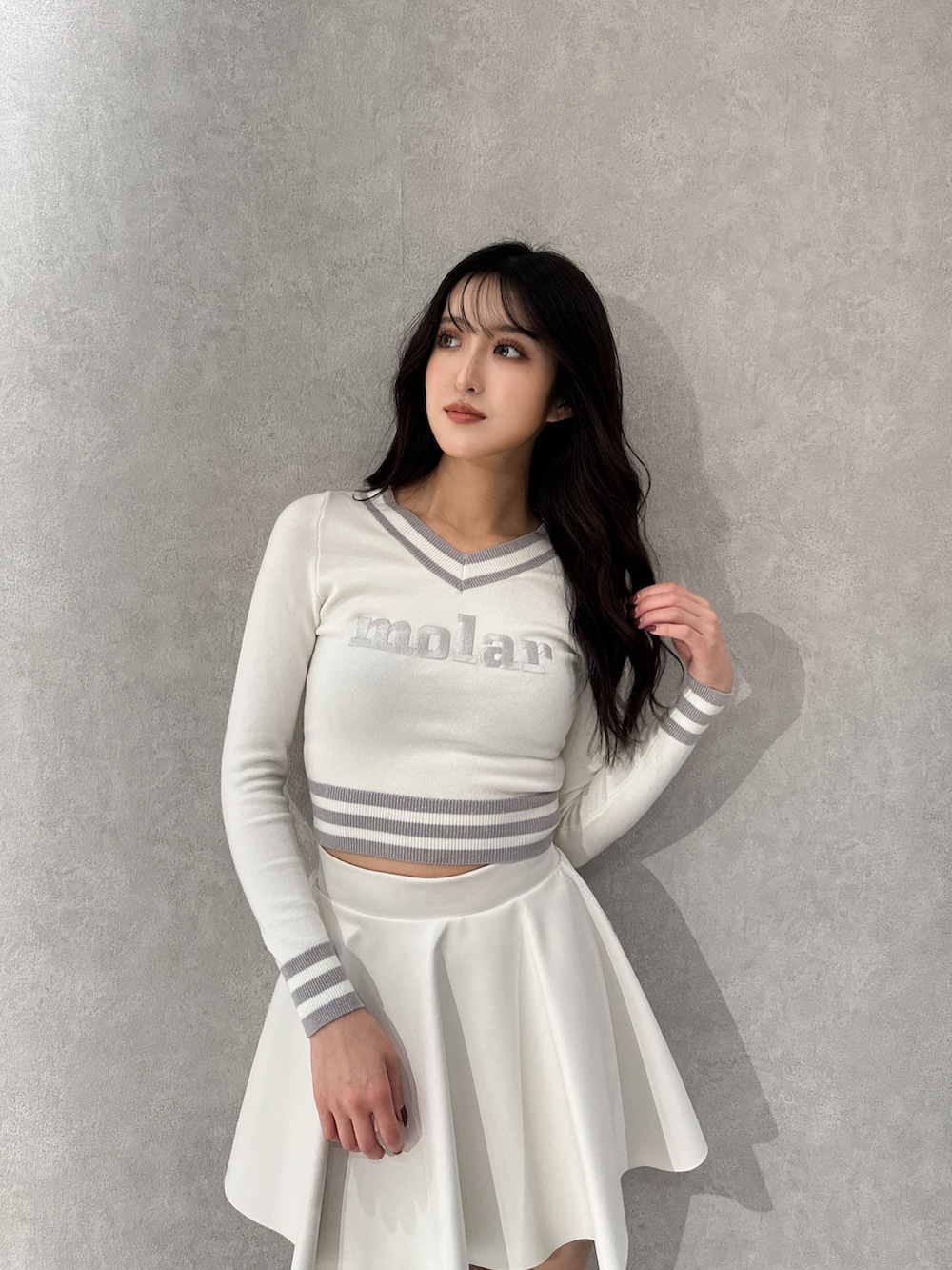 ホワイト系のブルゾン、ホワイト系のニット/セーター、ホワイト系のスカートを着用したレディースの冬コーディネートの6枚目の写真