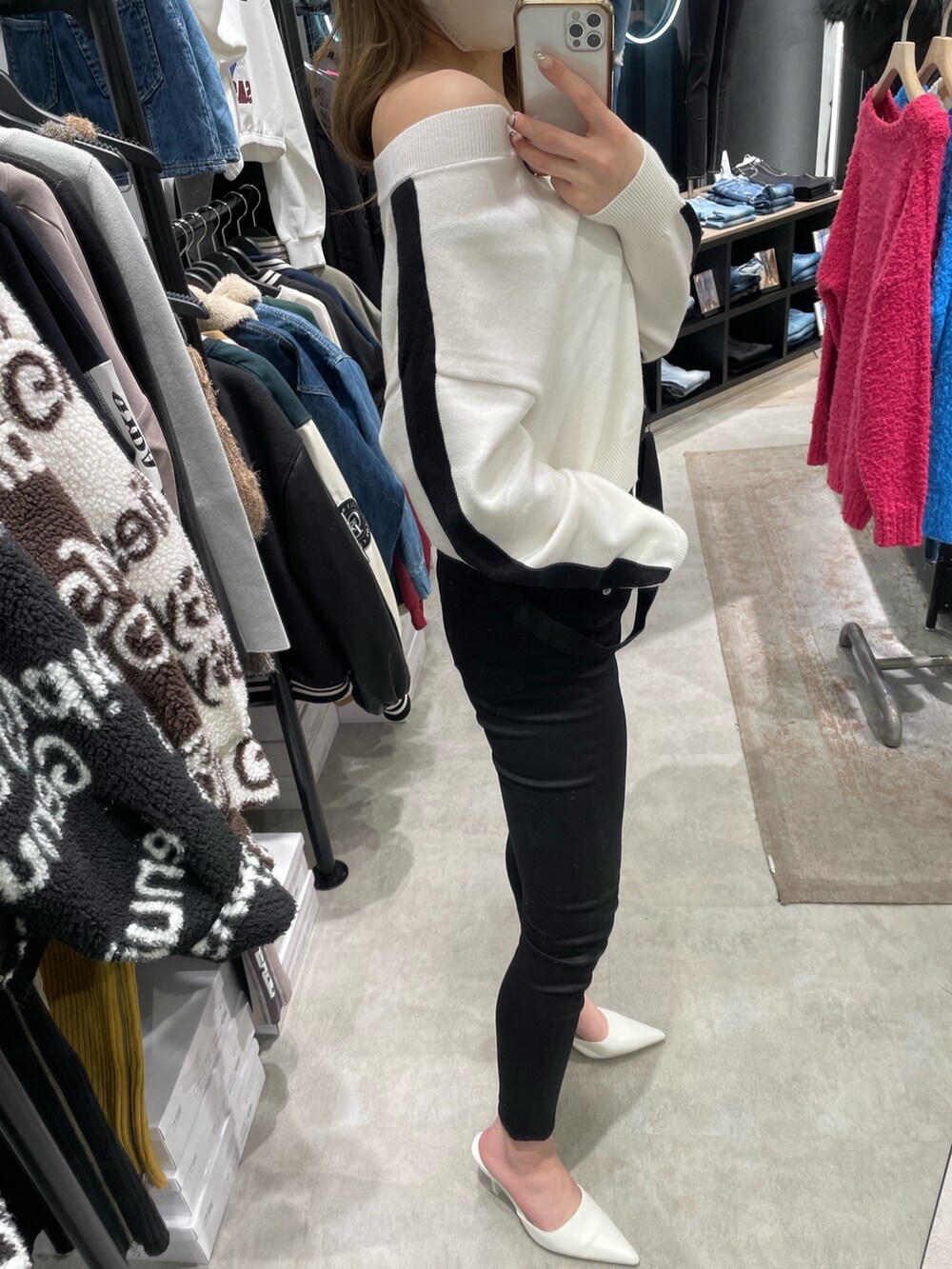 ホワイト系のニット/セーター、ブラック系のサロペット/オーバーオール、ホワイト系のパンプスを着用したレディースの冬コーディネートの4枚目の写真