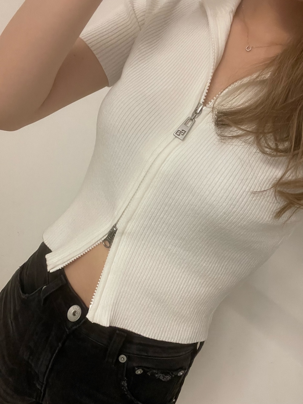 ブラック系のデニムパンツ、ホワイト系のパンプス、ホワイト系のニット/セーターを着用したレディースの夏コーディネートの6枚目の写真