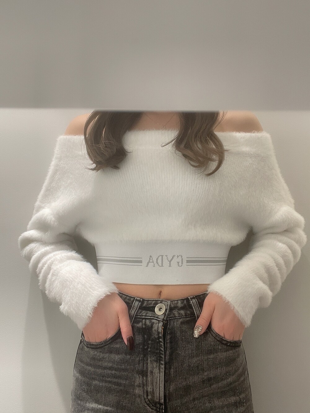 ホワイト系のニット/セーター、ホワイト系のパンプス、ブラック系のデニムパンツを着用したレディースの秋コーディネートの4枚目の写真