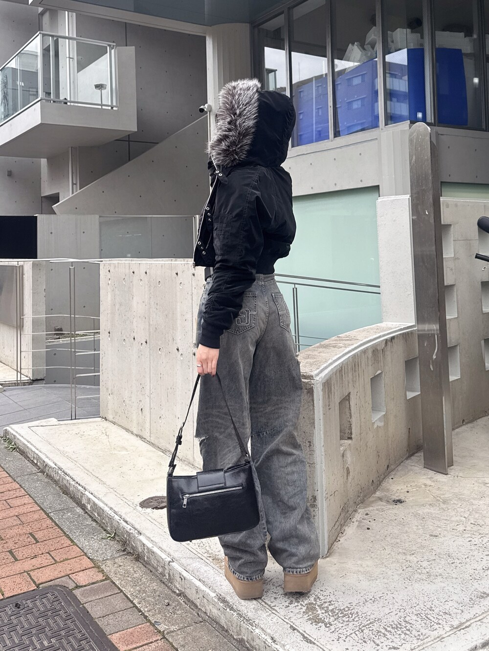 ブラック系のブルゾン、その他のニット/セーター、ブラック系のハンドバッグを着用したレディースの秋コーディネートの5枚目の写真