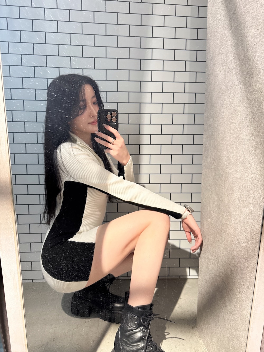 ホワイト系のワンピース、ブラック系のブーツを着用したレディースの冬コーディネートの3枚目の写真