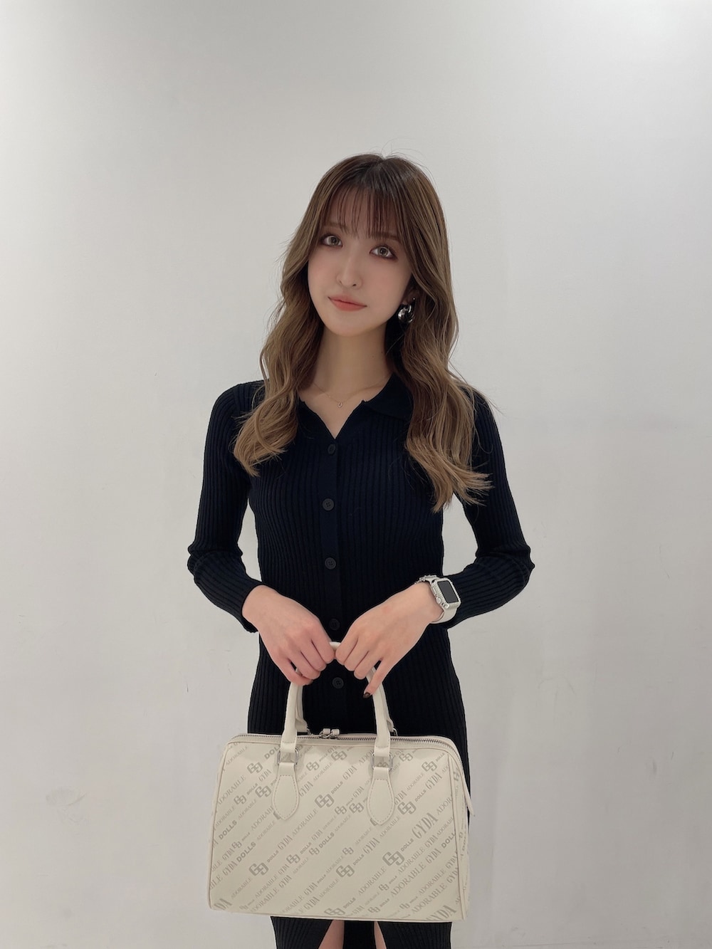 ブラック系のワンピース、ブラック系のブーツ、ホワイト系のボストンバッグを着用したレディースの秋コーディネートの5枚目の写真