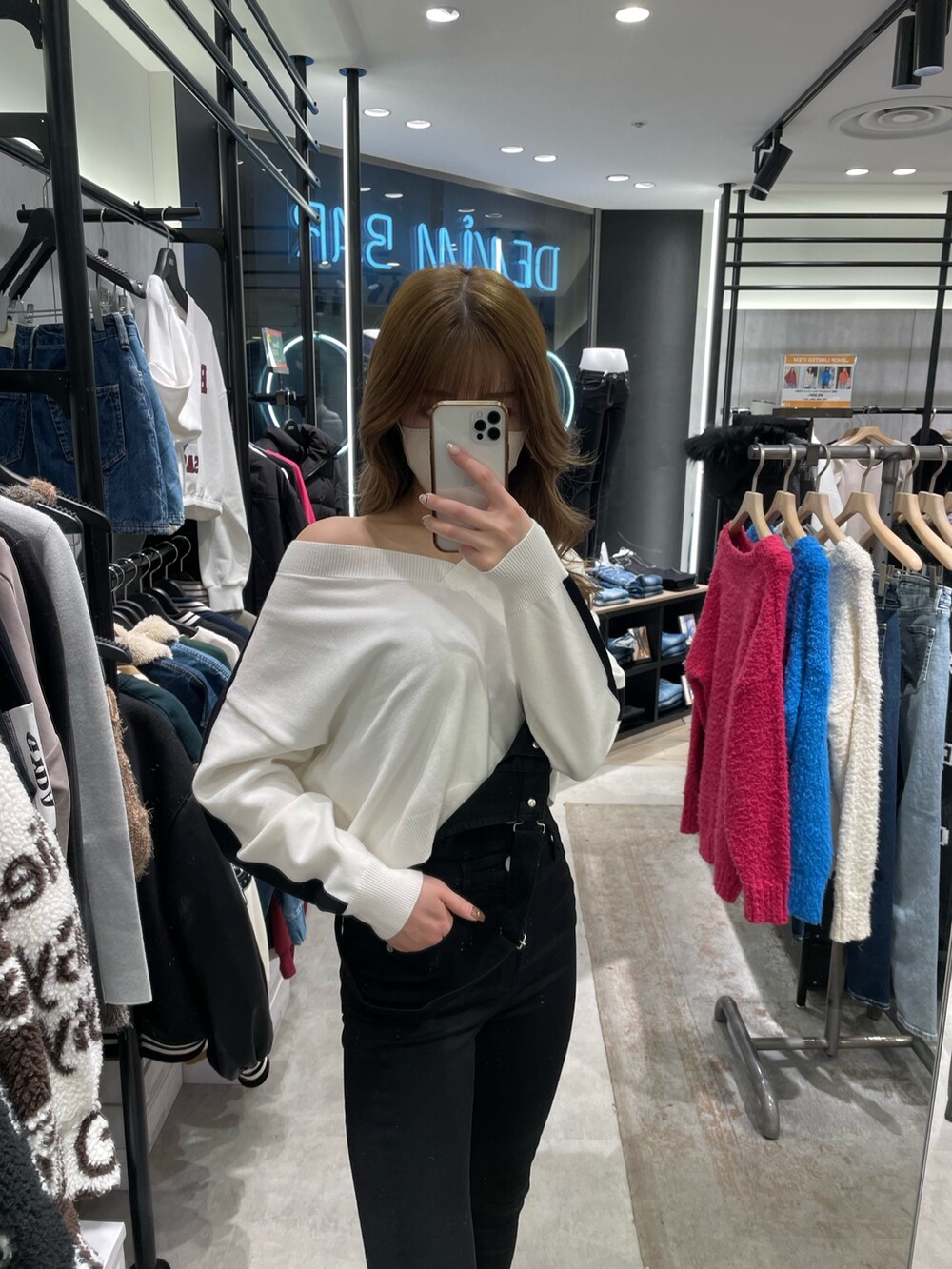 ホワイト系のニット/セーター、ブラック系のサロペット/オーバーオール、ホワイト系のパンプスを着用したレディースの冬コーディネートの3枚目の写真