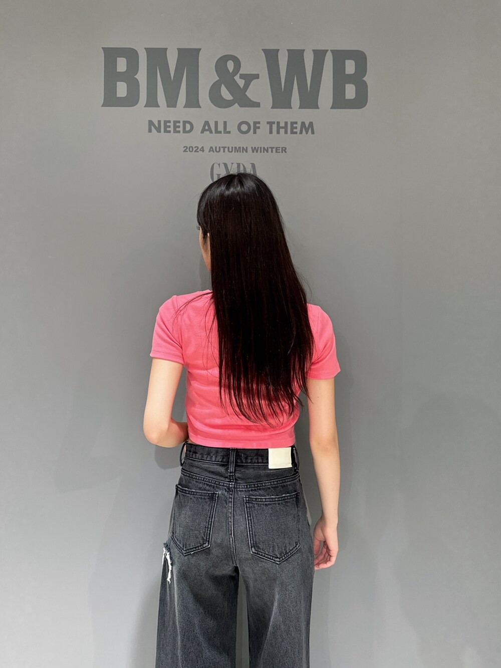 ピンク系のTシャツ/カットソー、ブラック系のデニムパンツ、ブラック系のパンプスを着用したレディースの夏コーディネートの4枚目の写真