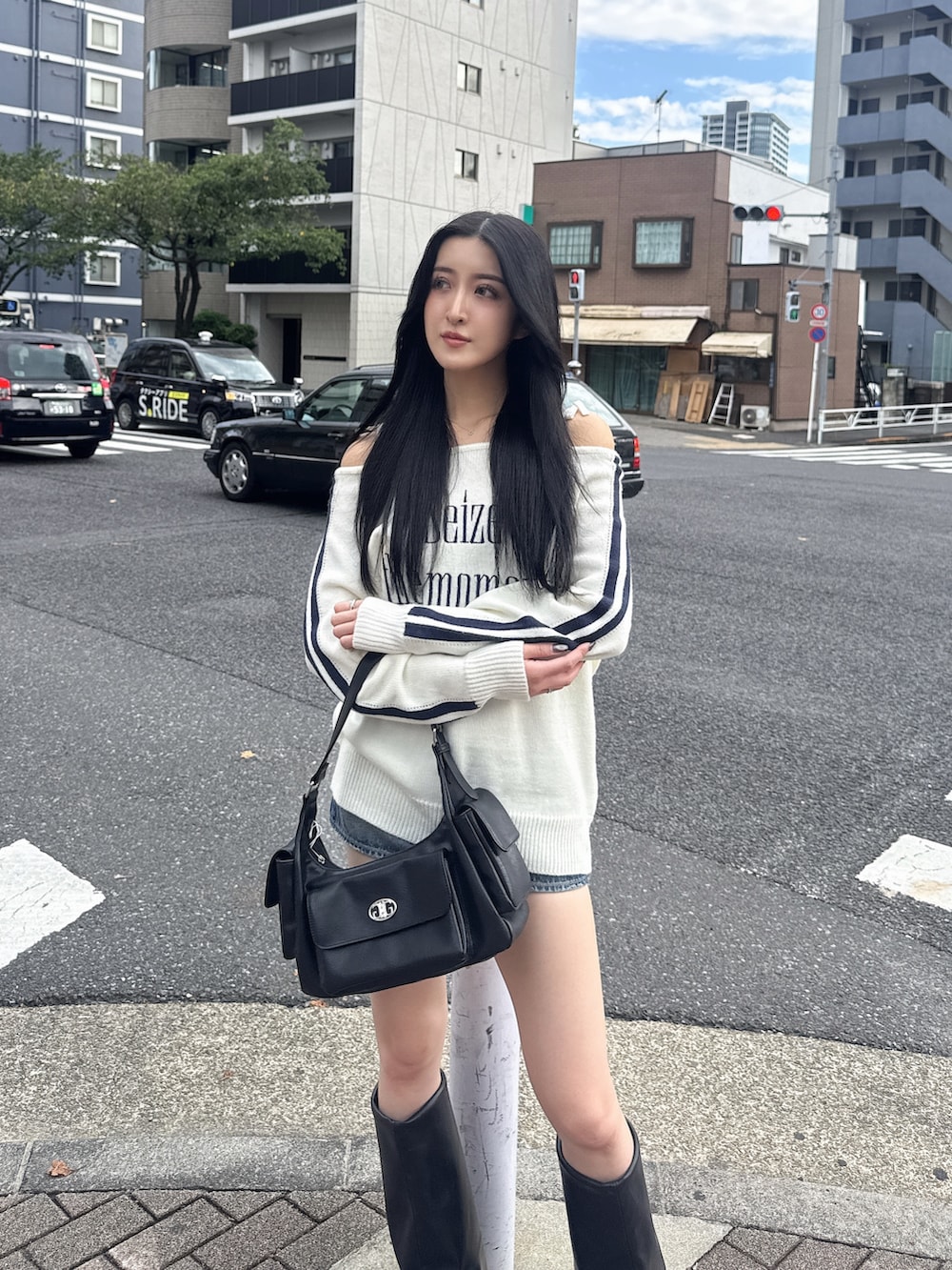 ホワイト系のニット/セーター、ブルー系のデニムスカート、ブラック系のブーツを着用したレディースの秋コーディネートの3枚目の写真