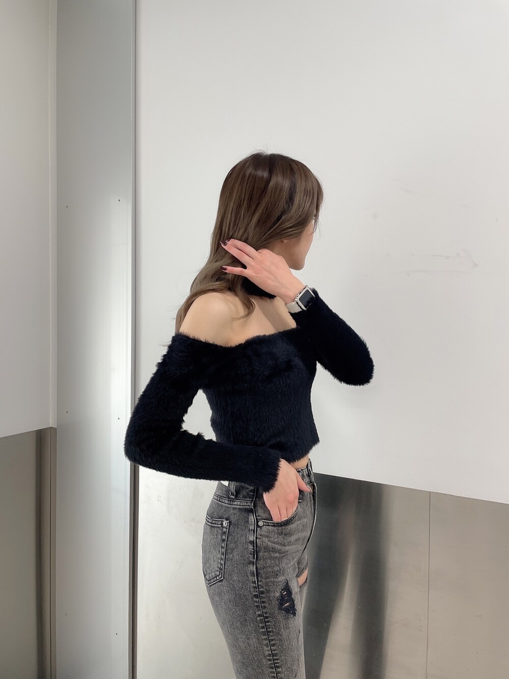 ブラック系のデニムパンツ、ブラック系のニット/セーター、ブラック系のパンプスを着用したレディースの秋コーディネートの6枚目の写真