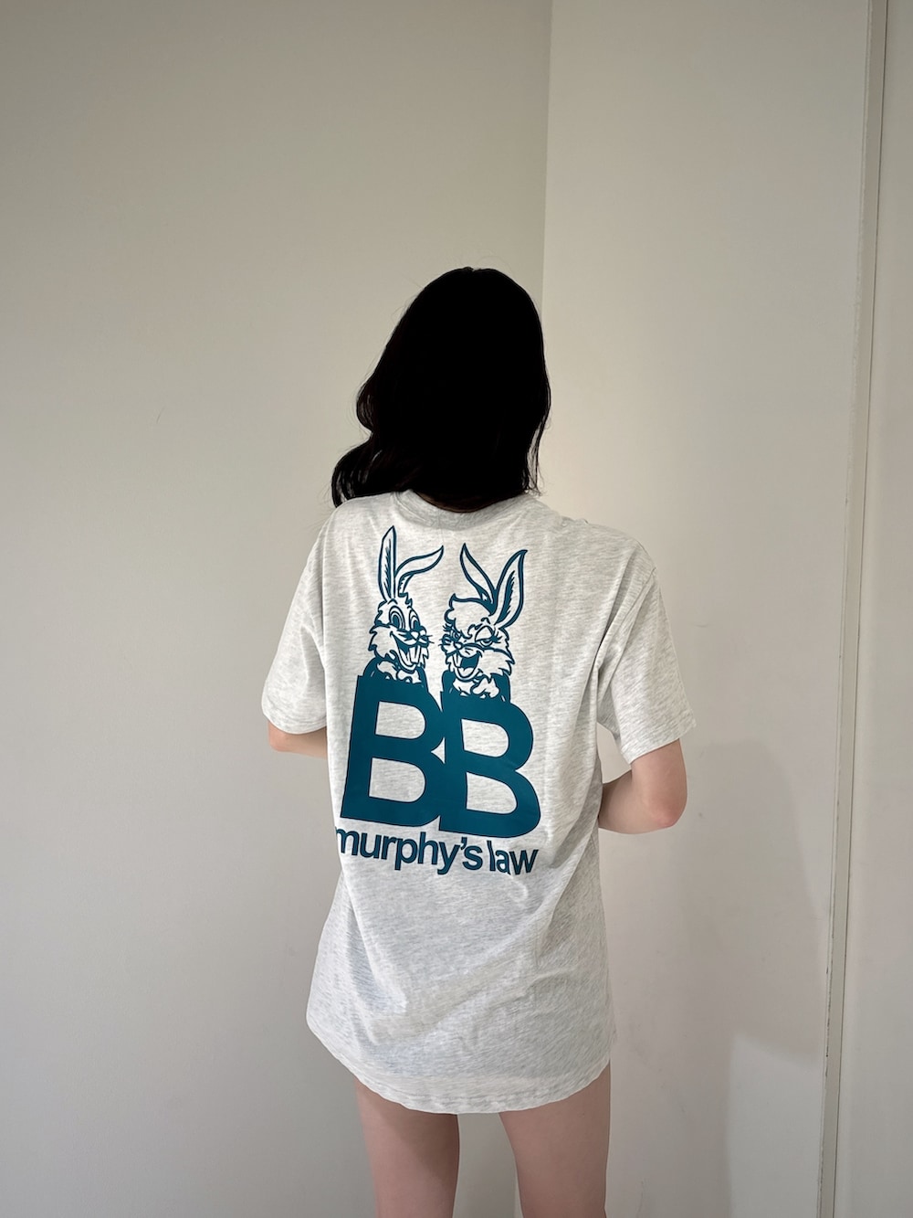 グレー系のTシャツ/カットソー、ブラック系のデニムスカート、ブラック系のサンダルを着用したレディースの夏コーディネートの5枚目の写真