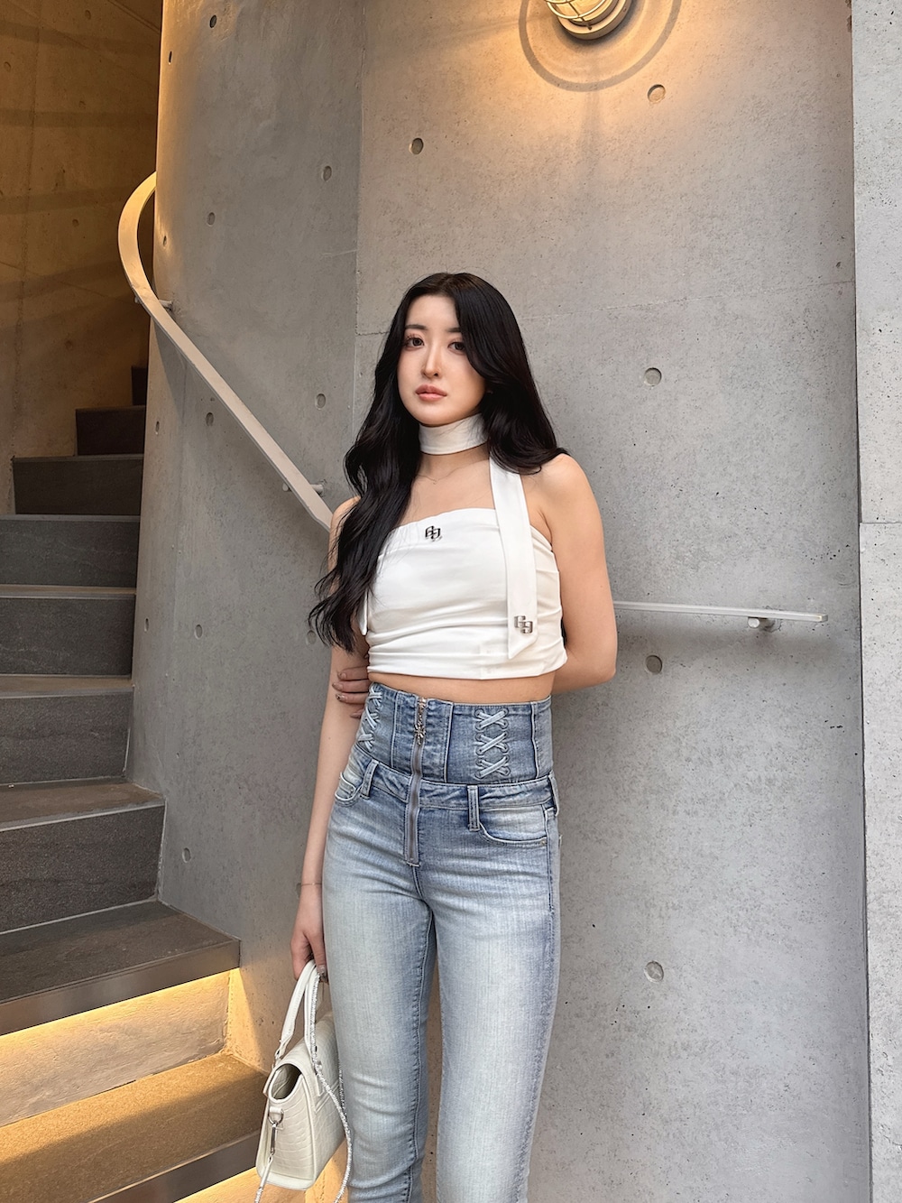 ホワイト系のTシャツ/カットソー、ブルー系のデニムパンツ、ホワイト系のハンドバッグを着用したレディースの春コーディネートの3枚目の写真