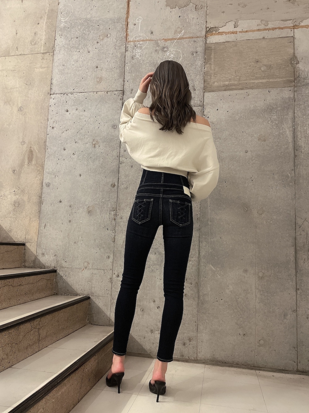 ホワイト系のスウェット、ブルー系のデニムパンツ、ブラック系のパンプスを着用したレディースの夏コーディネートの2枚目の写真