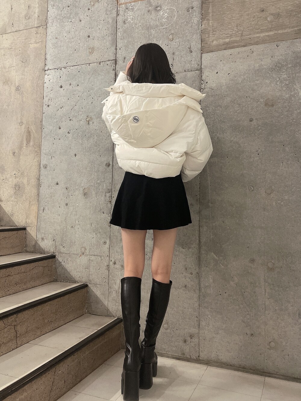 ホワイト系のダウンジャケット/コート、ブラック系のワンピース、ブラック系のブーツを着用したレディースの冬コーディネートの2枚目の写真