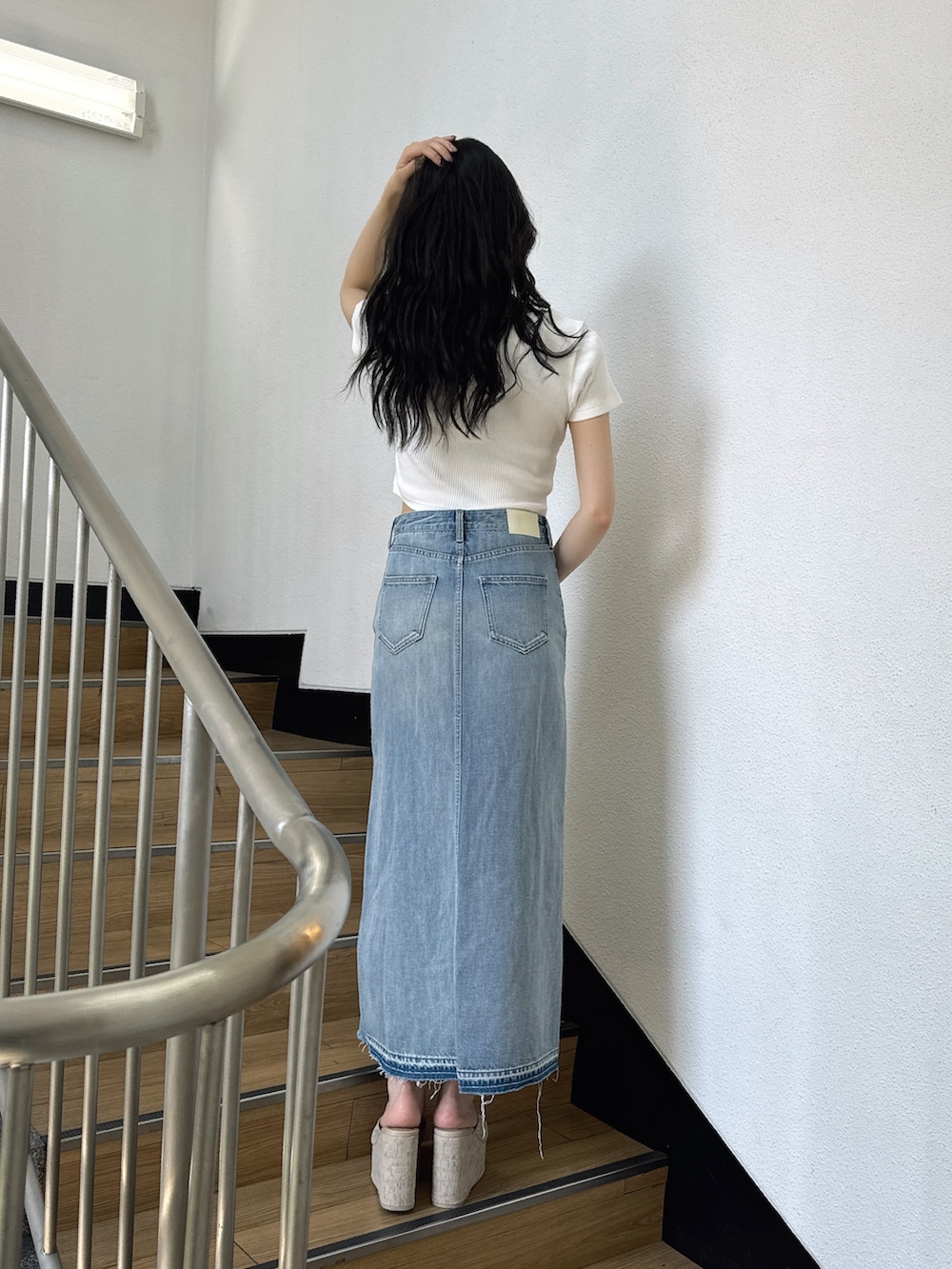 ホワイト系のTシャツ/カットソー、ブルー系のデニムスカート、ホワイト系のサンダルを着用したレディースの夏コーディネートの5枚目の写真