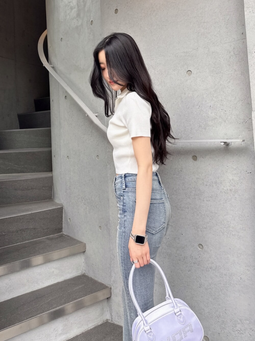 ホワイト系のニット/セーター、ブルー系のデニムパンツ、ホワイト系のボストンバッグを着用したレディースの夏コーディネートの5枚目の写真
