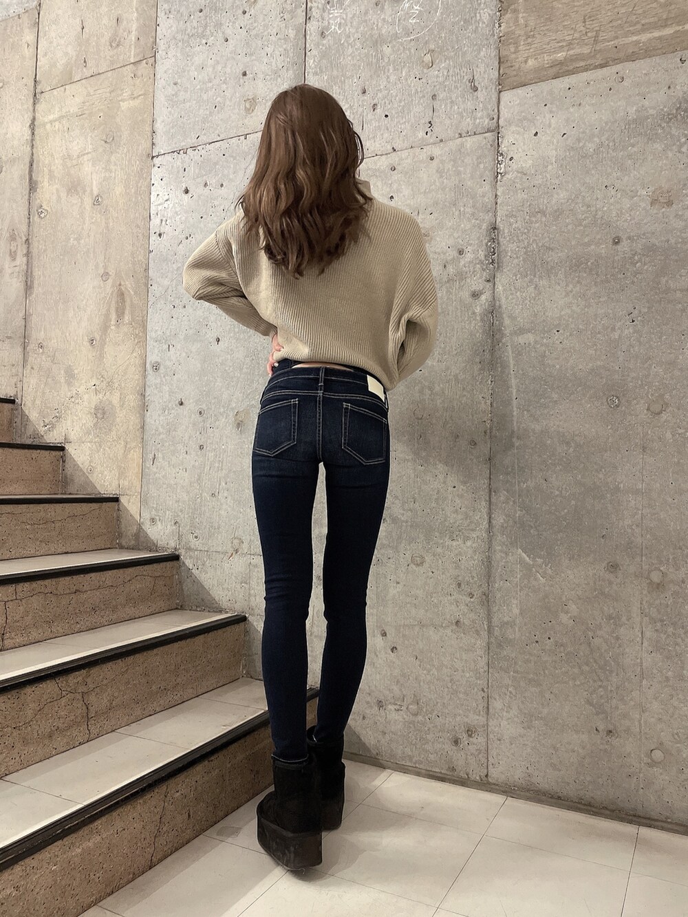 ベージュ系のニット/セーター、ブルー系のデニムパンツ、ブラック系のブーツを着用したレディースの冬コーディネートの3枚目の写真