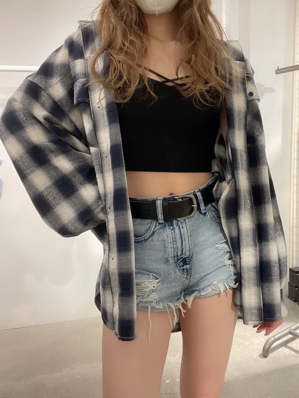 ブラック系のブーツ、ブラック系のキャミソール、ブルー系のデニムパンツを着用したレディースの春コーディネートの5枚目の写真