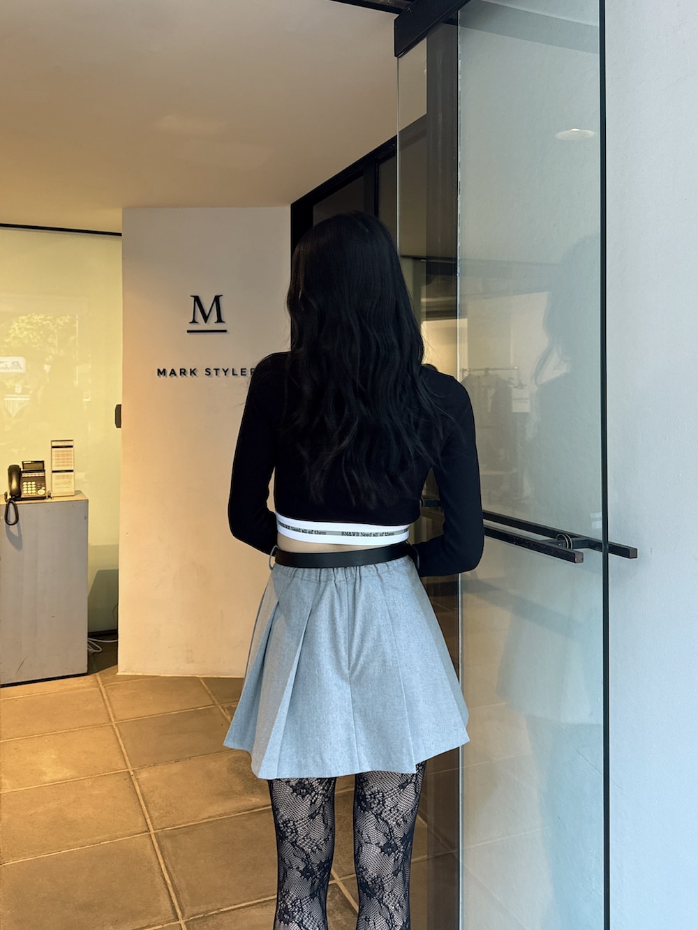 ブラック系のTシャツ/カットソー、グレー系のスカート、ブラック系のブーツを着用したレディースの夏コーディネートの4枚目の写真