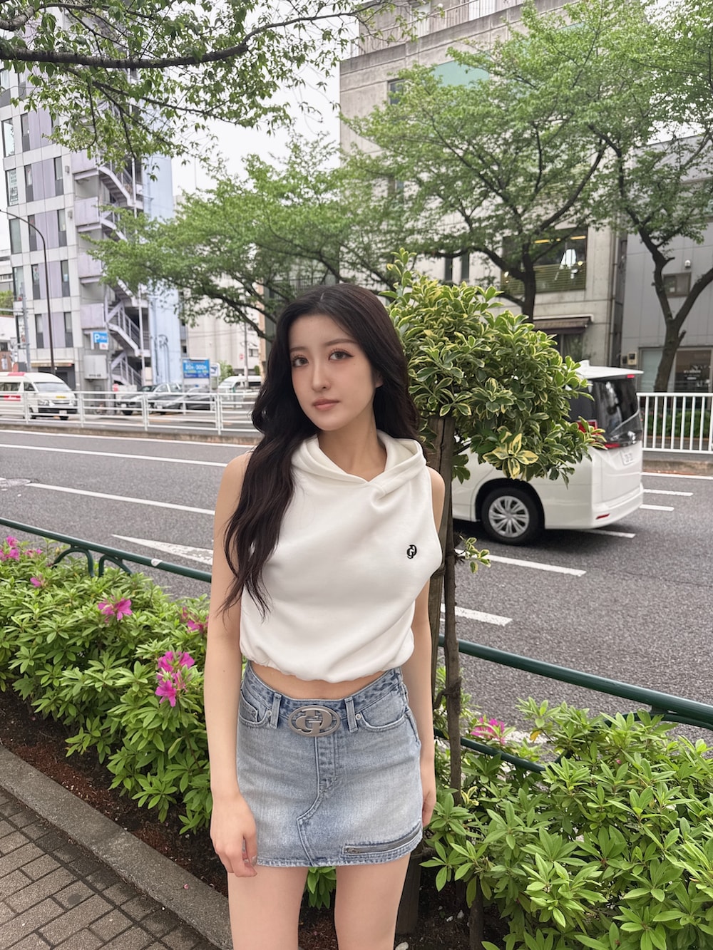 ホワイト系のパーカー、ブルー系のデニムスカート、ブラック系のサンダルを着用したレディースの春コーディネートの2枚目の写真