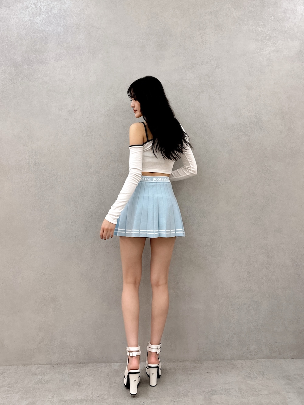 ブルー系のスカート、ホワイト系のTシャツ/カットソー、ホワイト系のブーツを着用したレディースの春コーディネートの2枚目の写真