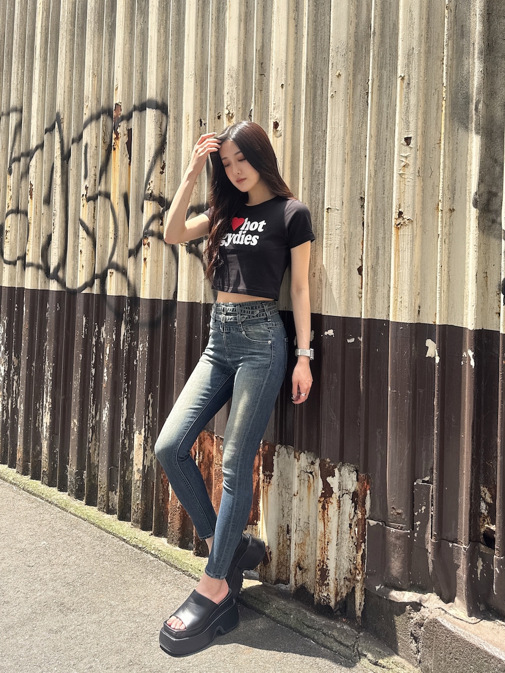 ブラック系のTシャツ/カットソー、ブルー系のデニムパンツ、ブラック系のサンダルを着用したレディースの春コーディネートの2枚目の写真