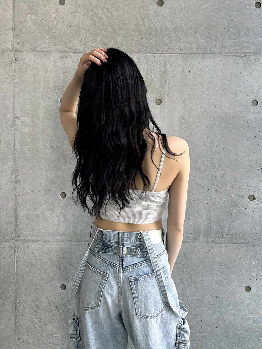 グレー系のキャミソール、ブルー系のデニムパンツ、ブラック系のサンダルを着用したレディースの夏コーディネートの4枚目の写真