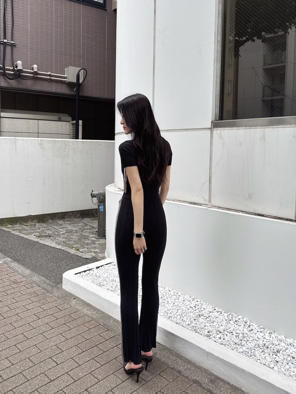 ブラック系のその他パンツ、ブラック系のニット/セーター、ブラック系のパンプスを着用したレディースの春コーディネートの3枚目の写真