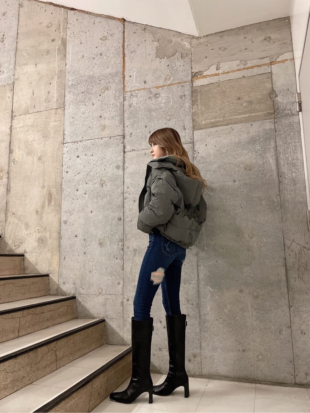 ベージュ系のダウンジャケット/コート、ブラック系のブーツ、グレー系のスウェットを着用したレディースの秋コーディネートの5枚目の写真