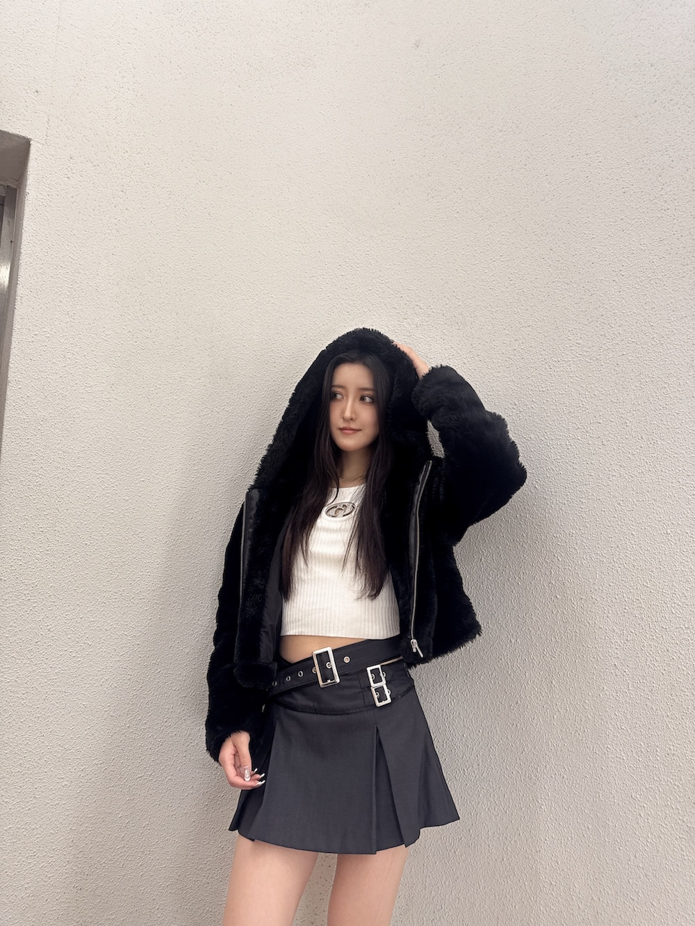 ブラック系のスカート、ブラック系のブーツ、ブラック系のニット/セーターを着用したレディースの秋コーディネートの2枚目の写真