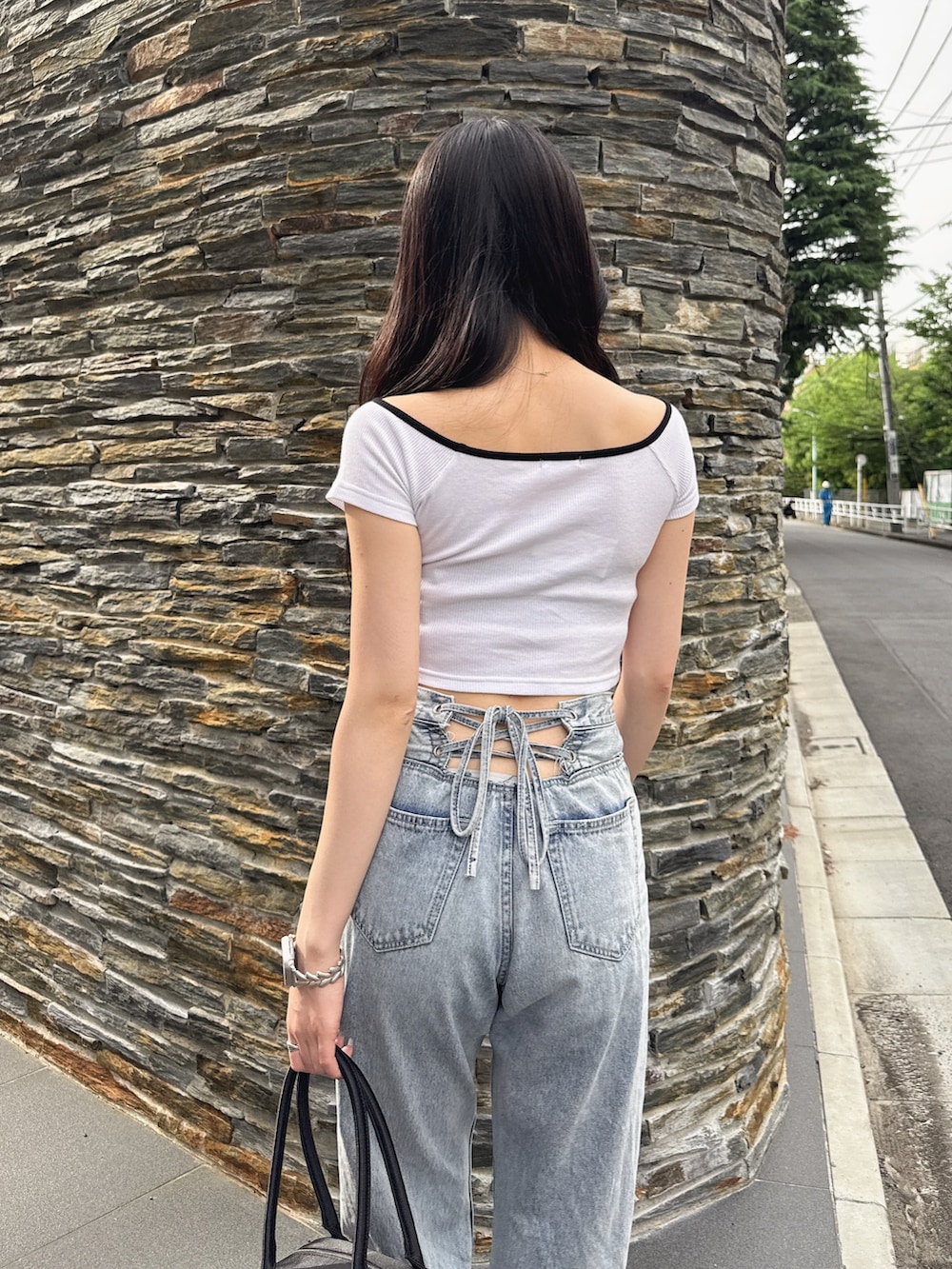 ホワイト系のTシャツ/カットソー、ブラック系のボストンバッグ、ブルー系のデニムパンツを着用したレディースの夏コーディネートの6枚目の写真