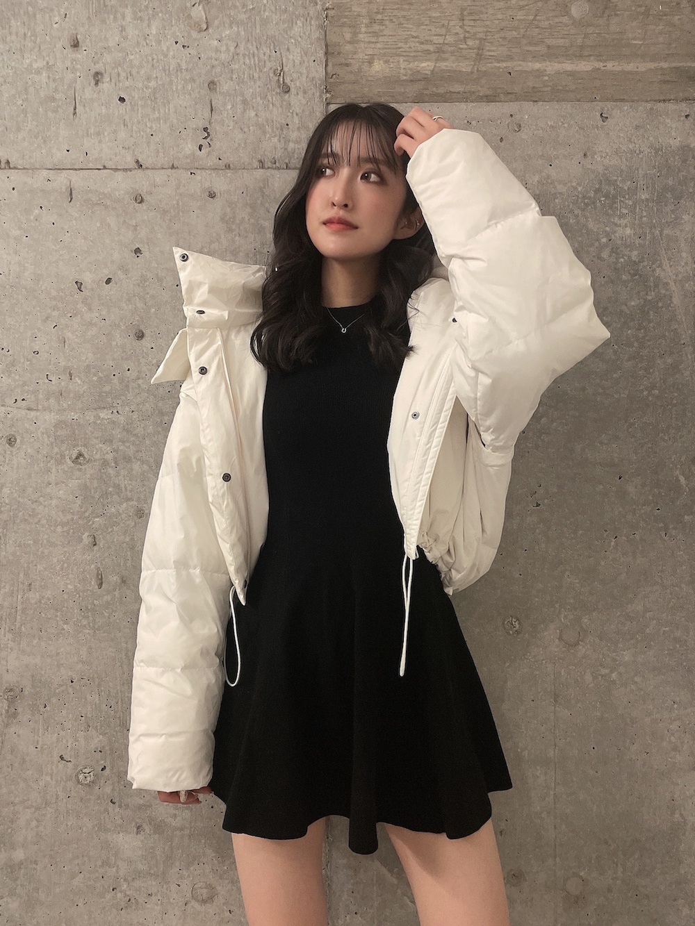 ホワイト系のダウンジャケット/コート、ブラック系のワンピース、ブラック系のブーツを着用したレディースの冬コーディネートの3枚目の写真