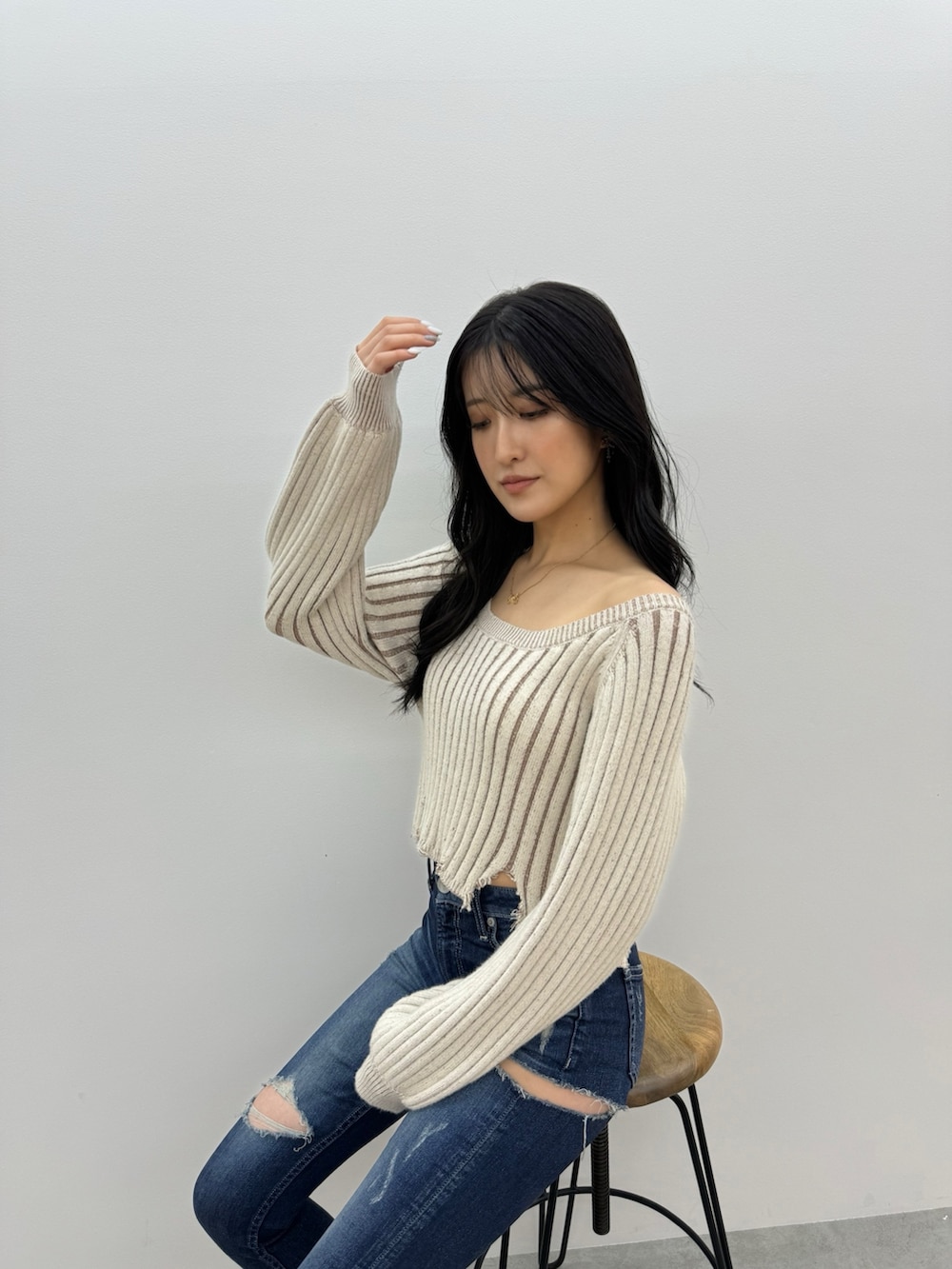 ベージュ系のニット/セーター、ブルー系のデニムパンツ、ホワイト系のパンプスを着用したレディースの冬コーディネートの2枚目の写真