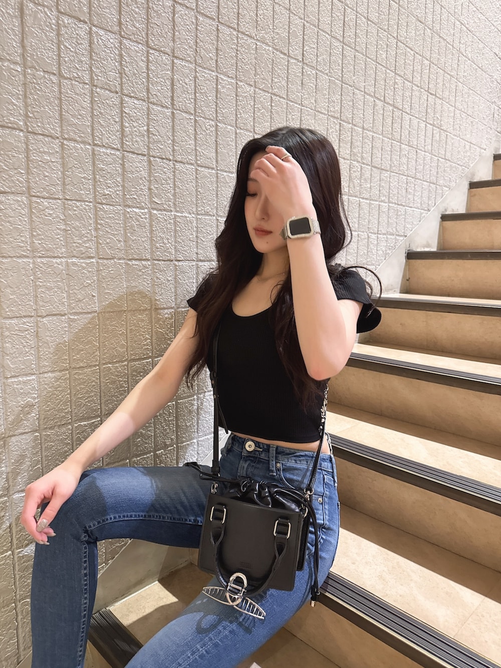ブラック系のTシャツ/カットソー、ブルー系のデニムパンツ、ブラック系のサンダルを着用したレディースの春コーディネートの2枚目の写真