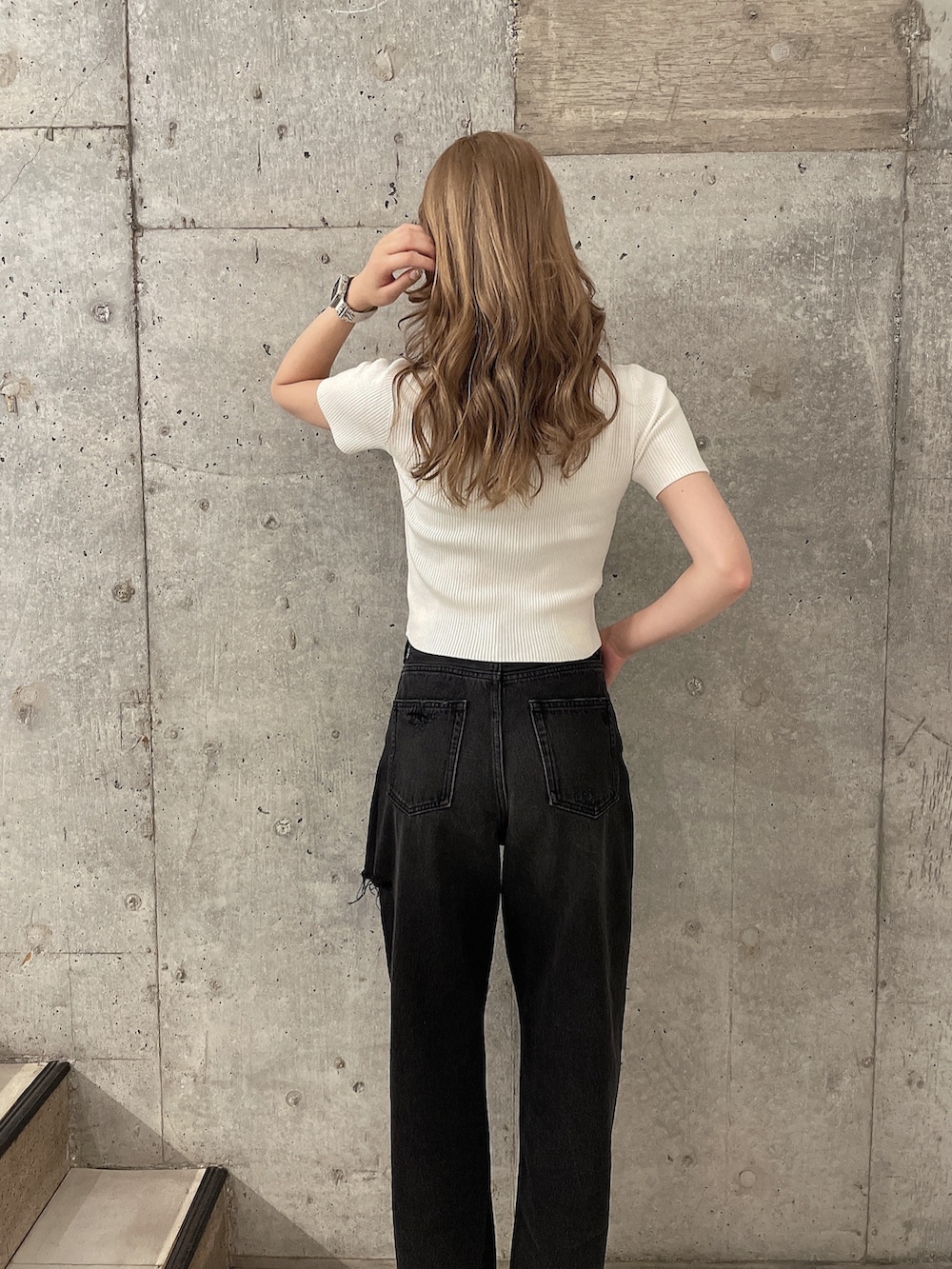 ブラック系のデニムパンツ、ホワイト系のパンプス、ホワイト系のニット/セーターを着用したレディースの夏コーディネートの4枚目の写真