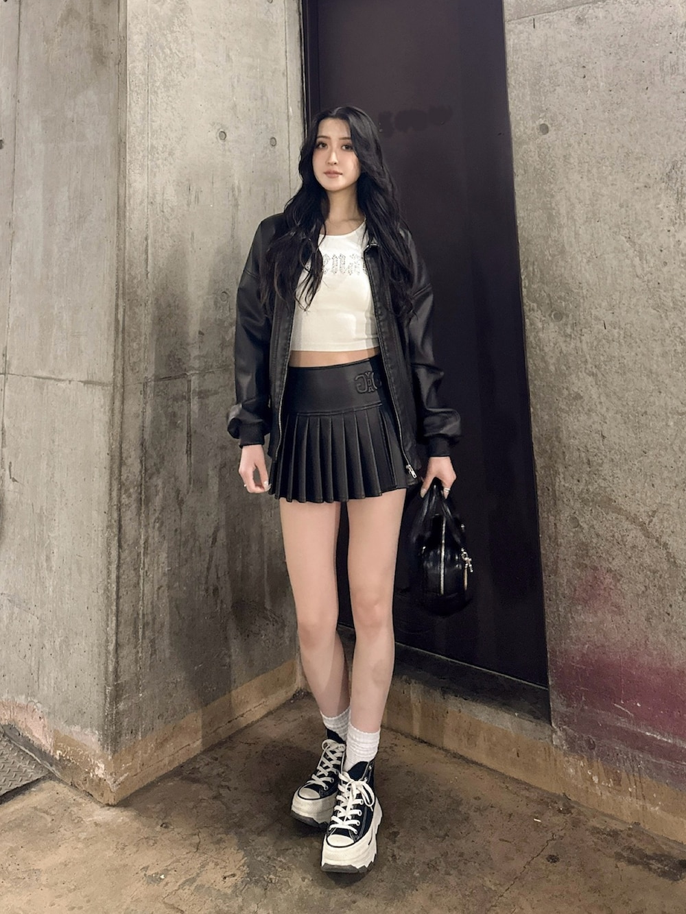 ブラック系のブルゾン、ホワイト系のニット/セーター、ブラック系のスカートを着用したレディースの冬コーディネートの2枚目の写真