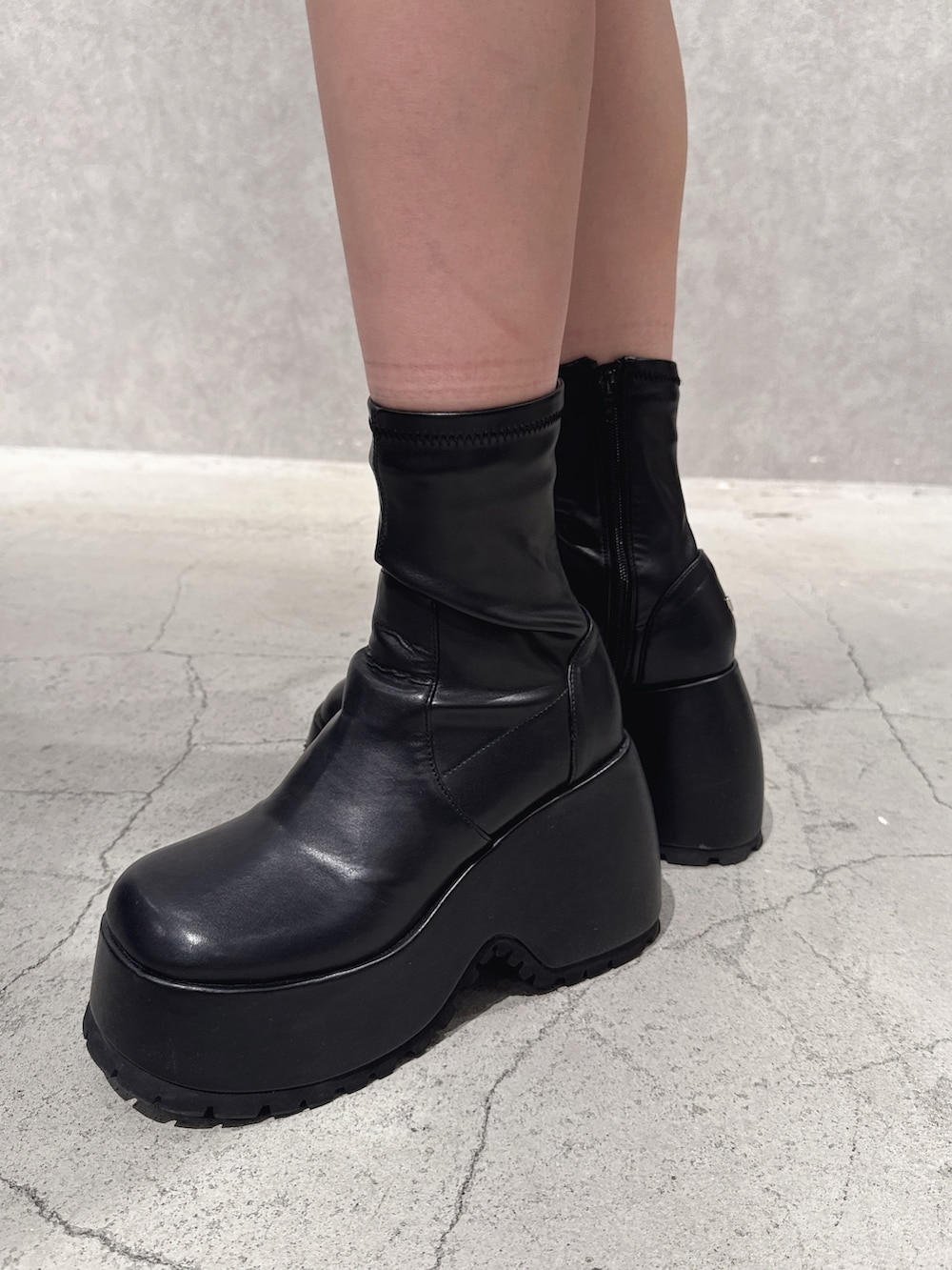 ホワイト系のスウェット、ブラック系のデニムパンツ、ブラック系のブーツを着用したレディースの秋コーディネートの8枚目の写真